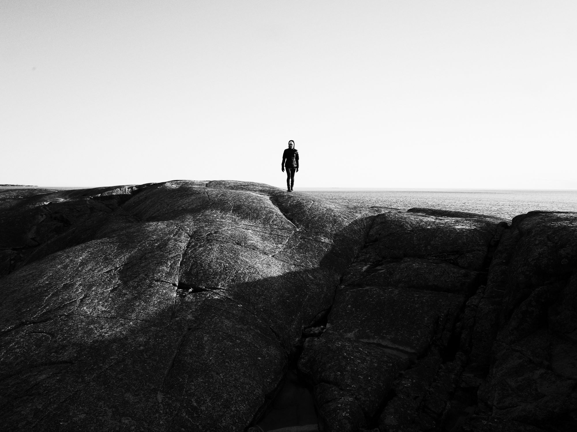 En ensam person på ett berg, svartvit bild