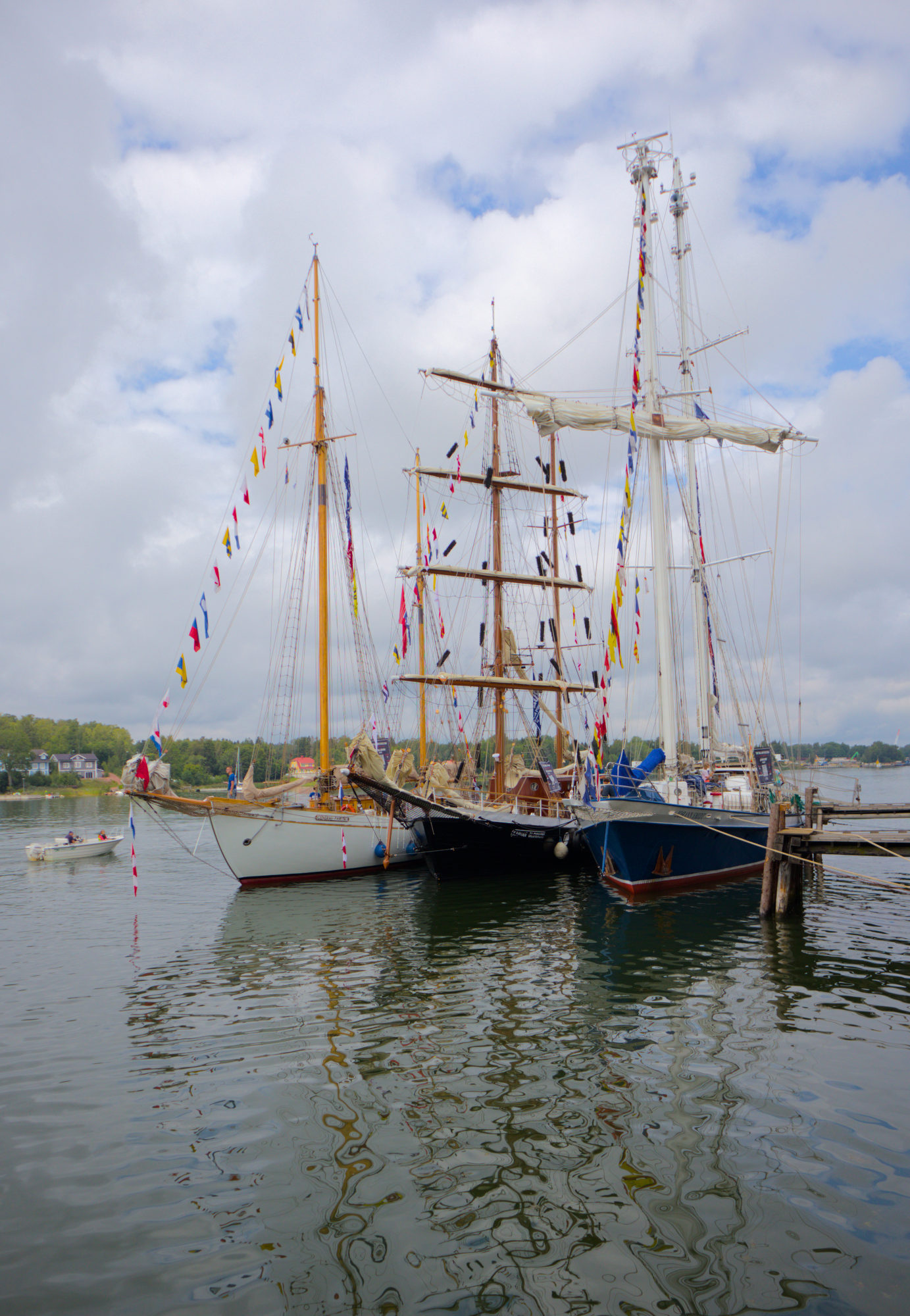 Tre fartyg från Tall Ships Races står förtöjda i bredd vid en brygga.