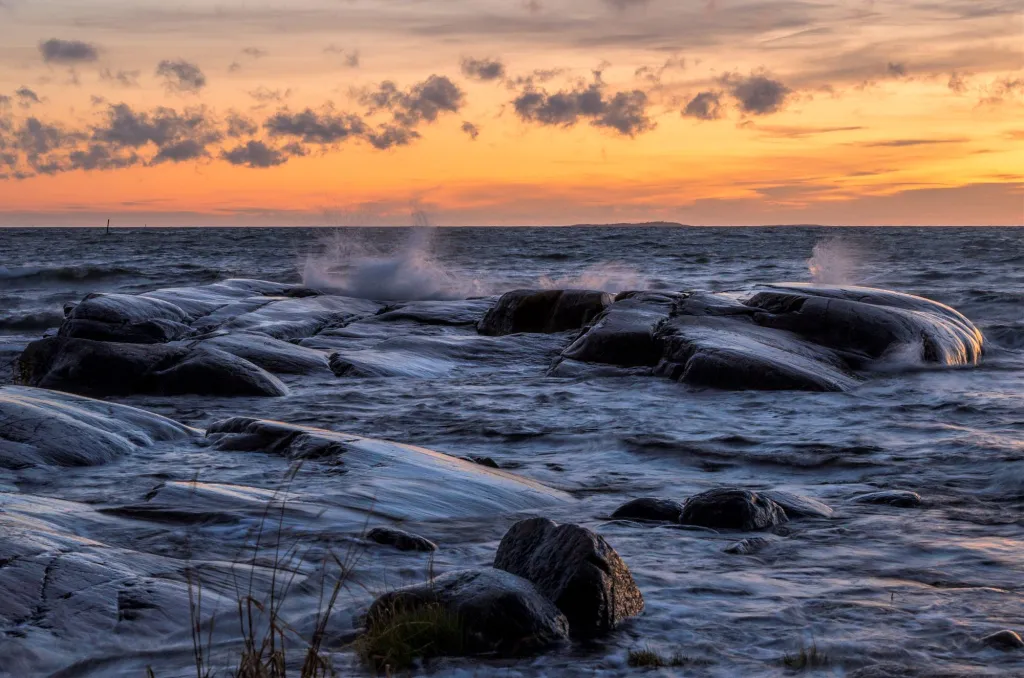 Vågor som slår mot strandstenar.