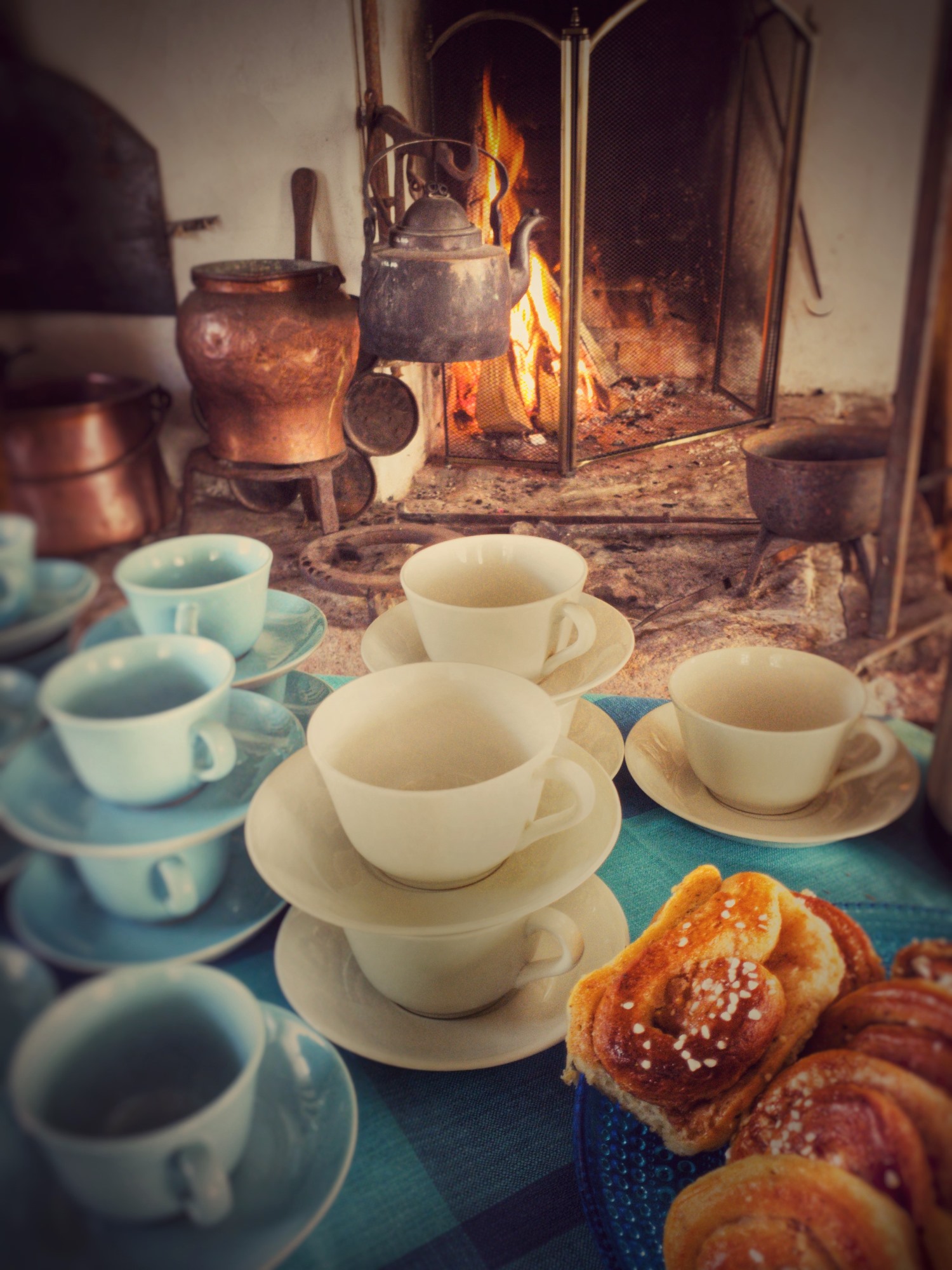 Kaffekoppar framför en spis med öppen eld